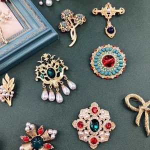 Gedetailleerd overzicht van vintage barokke broches met matgouden afwerking en edelstenen