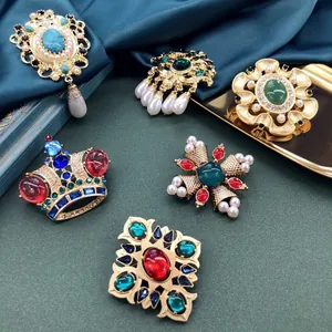 Prachtige close-up details van barokke vintage broches met kleurrijke stenen en parels