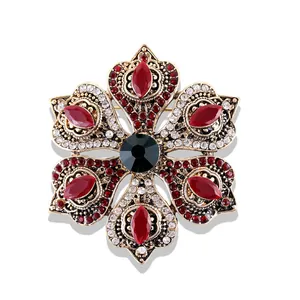 Vue macro d'une broche baroque vintage avec pierres marquises rouges et cristal vert
