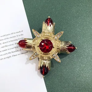 Macro-weergave van gedetailleerde vintage barokke gouden broche met rode edelstenen