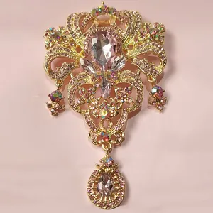 Vue détaillée d'une broche couronne dorée avec des strass rose en forme de goutte