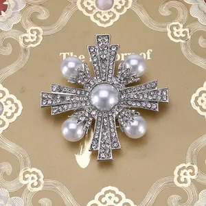 Detailopname van een barokke vintage kruisbroche met parels en glanzende strasstenen