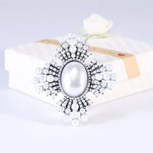 Detailweergave van luxe barokke vintage kruisbroche met parels en strassteentjes