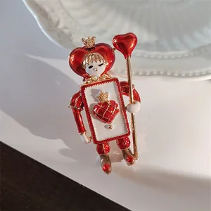 Detailed macro view of a vintage heart soldier brooch with red enamel and gold finish