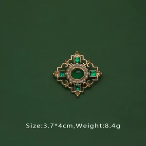 Détail d'une broche baroque vintage avec perles, pierres émeraude et mesures