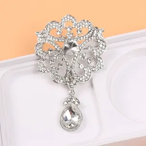Broche de style cour vintage complexe avec strass argentés et un pendentif en goutte.