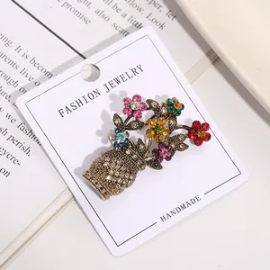 Detailed view of a vintage flower basket brooch with colorful rhinestones on a white card