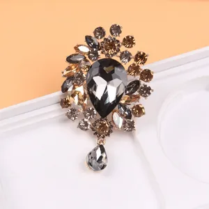 Détail exquis de cristaux gris et champagne sur cette broche de style vintage