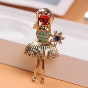 Detailed macro view of a vintage gold-toned girl brooch with rhinestone accents