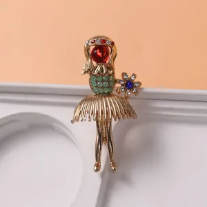 Close-up of an elegant gold-toned girl brooch with green and red rhinestones.