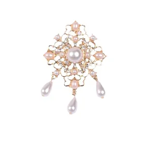 Elegante broche de estilo barroco vintage con perlas y pedrería en una base de metal dorado.
