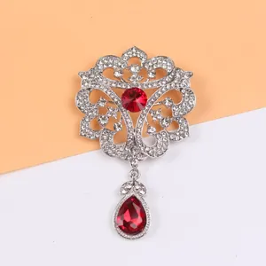 Gros plan détaillé d'une broche de style cour vintage avec pierre rouge et cristaux