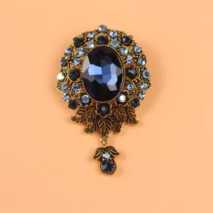 Vue détaillée d'une luxueuse broche de style vintage avec une grande pierre précieuse bleue