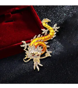Detailansicht goldene Drachenbrosche mit klaren Strasssteinen und roten Augen