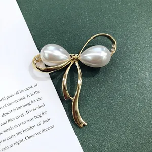 Gedetailleerde weergave van een vintage barokke strikbroche met parels en gouden afwerking