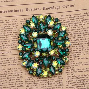 Vintage flower brooch with emerald green crystals and elegant round fashion jewelry design