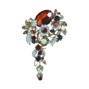 Elegante vintage bloemenbroche met een groot barnsteenkristal en blauwe strass-accenten