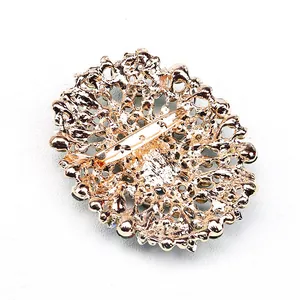 Back view of vintage gold-toned crystal glass brooch showing secure pin clasp detail