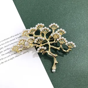 Detail van een barokke gouden dennenboom broche versierd met witte parels, vintage