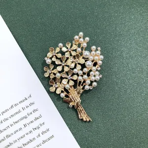 Detailopname van een vintage barokke gouden bloemboeket broche met parels en kristallen