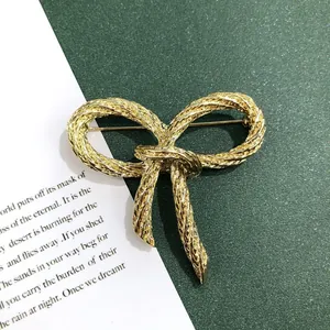 Detailopname van een vintage barokke gouden strikbrosche met geweven textuur