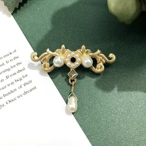 Gedetailleerde weergave van de vintage barokke kroonbroche met mat goud en parel