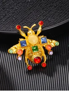 Primo piano della spilla ape oro vintage con vivaci strass di cristallo multicolore