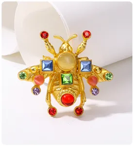 Dettaglio macro di una spilla ape vintage con strass colorati su metallo dorato