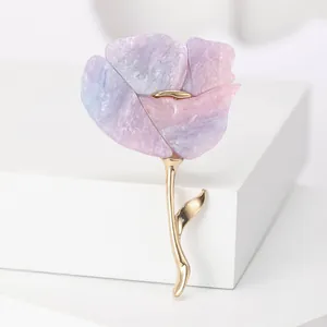 Détail d'une grande broche fleur aux pétales violets marbrés et tige dorée élégante