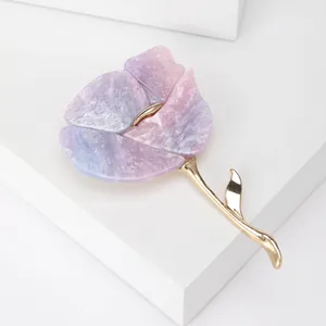 Détail d'une broche fleur avec pétales marbrés violets et tige dorée élégante