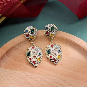 Detailopname van gouden vintage barok oorbellen met kleurrijke ronde strass steentjes