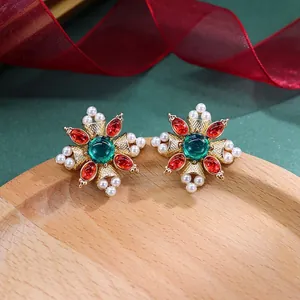 Detail van vintage barokke ster-oorbellen met rode strassteentjes en witte parels.