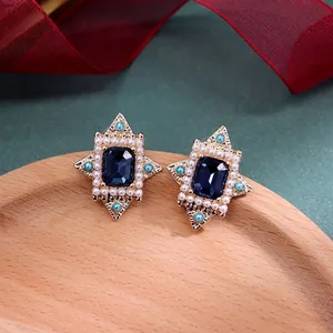Gedetailleerd overzicht van vintage barokke oorbellen met blauwe stras en parels
