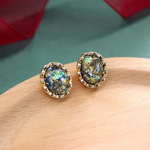 Macro-opname van vintage barokke ovale oorbellen met glanzende goud en blauwe hars textuur