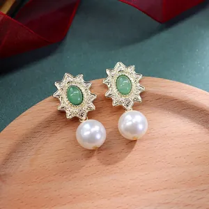 Detailopname van vintage barokke oorbellen met groene steen en parelhanger