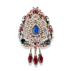 Vue détaillée de la broche baroque vintage avec cristaux colorés et filigrane d'or
