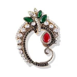 Gros plan d'une broche baroque vintage avec cristaux rouges et verts