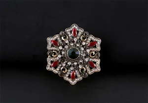 Vue détaillée d'une broche baroque vintage avec cristaux sur fond de tissu noir.