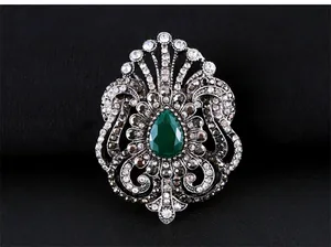 Broche vintage de style baroque avec cristal vert émeraude et détails en filigrane d'argent