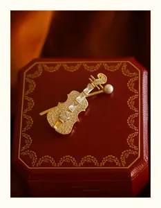 Macro view of an elegant gold violin brooch with sparkling rhinestones and pearl.