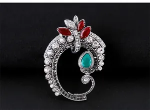 Broche baroque vintage élégante avec cristal goutte vert et pierres rouges.