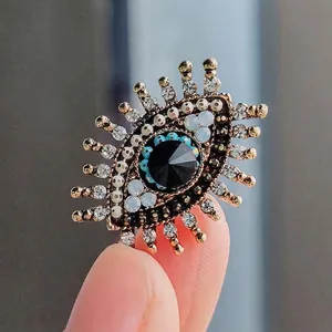 Vintage boze oog broche met strasstenen en parels voor zeer stijlvolle jasrevers