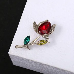 Detailed macro view of an elegant rose flower brooch featuring vibrant red and green crystals