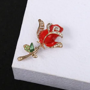 Detailed macro close-up of an elegant red rose flower brooch with sparkling rhinestone accents