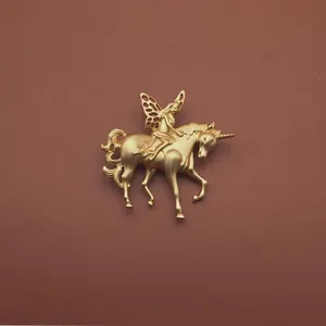 Elegante spilla barocca vintage dorata con una fata che cavalca un unicorno