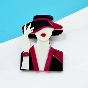 Detailed view of an elegant acrylic brooch featuring a lady in red and black outfit