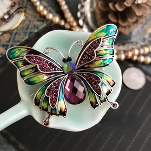 Gedetailleerde macro weergave van een elegante vintage emaille vlinder broche met kristallen.