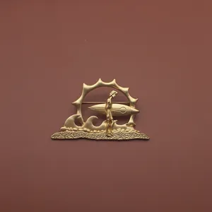 Detailansicht einer goldenen Vintage-Sonnensymbol-Brosche mit kunstvollem Surfer-Motiv