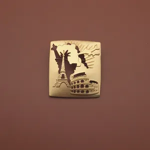 Nahaufnahme einer goldenen Brosche mit Reliefs von Eiffelturm und Kolosseum-Details