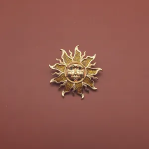 Detailansicht einer goldenen Sonnenbrosche im Vintage-Barockstil mit Glitzereffekt